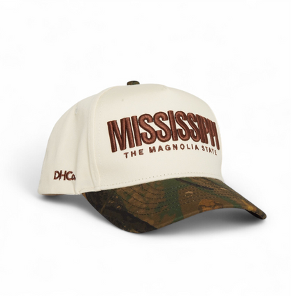 Destination Hat Co. Mississippi camo cap photographed closer to show the lettering and camouflage bill