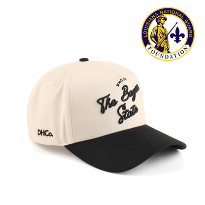 Destination Hat Co. Bayou script cap with beige crown and black bill, angled view