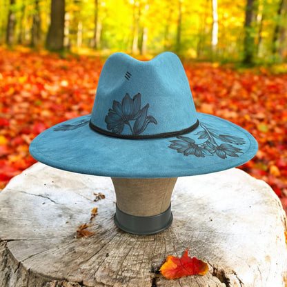 Side view of the Native Petals hat on a wooden stand among autumn trees