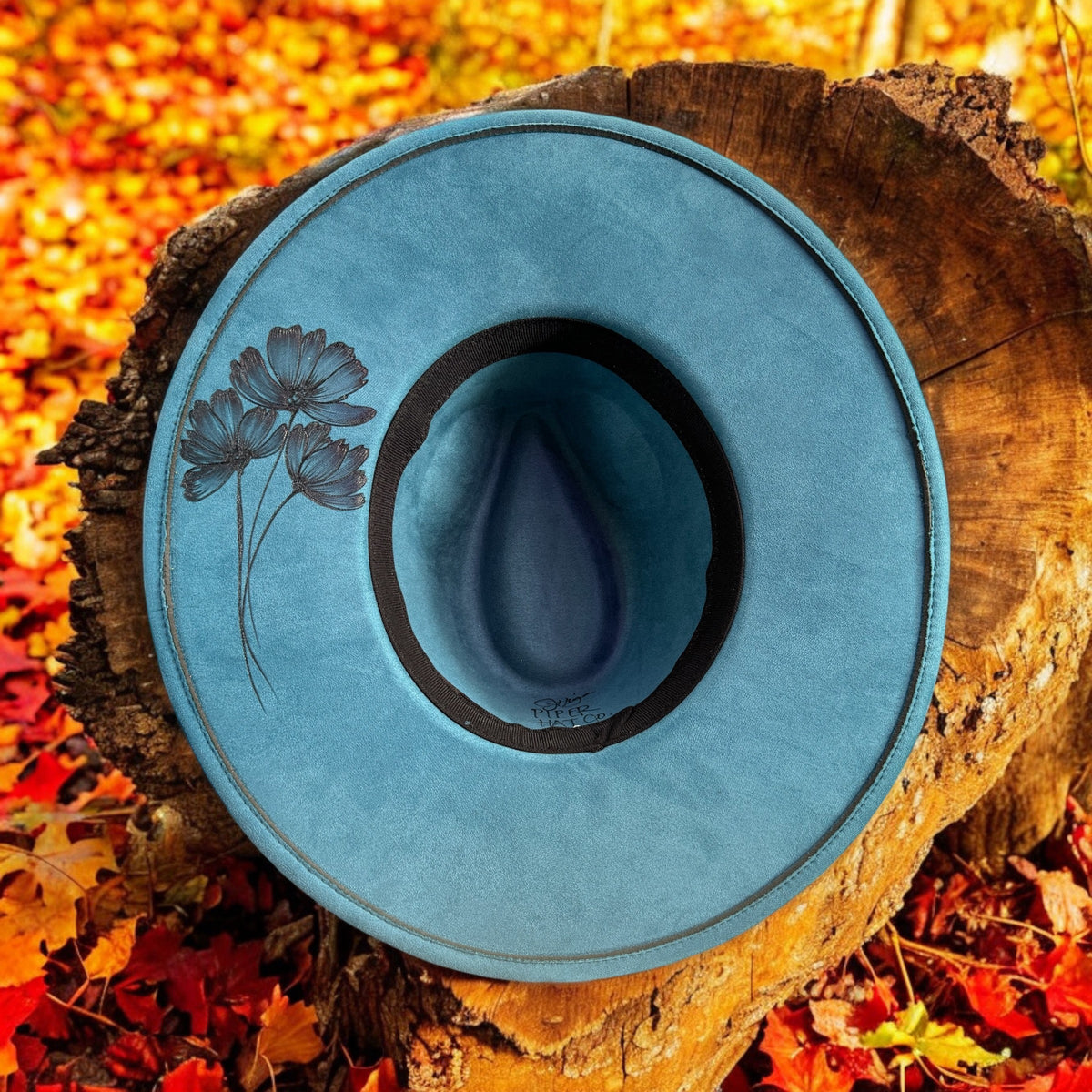 Underside of the blue Native Petals brim showing the inner band and burned floral details