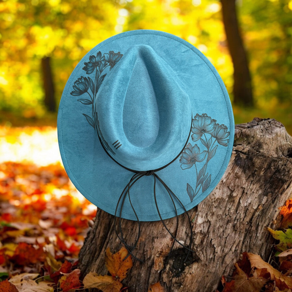 Peacock blue Piper Native Petals hat with burned flowers and leaves, overhead view