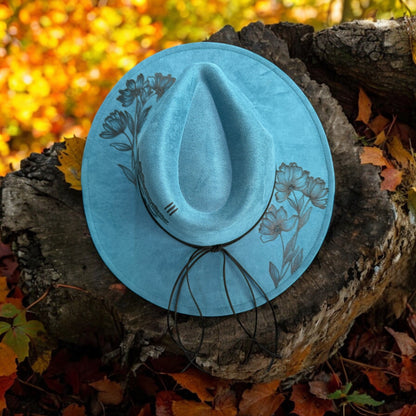 Native Petals hat tilted against an autumn woodland backdrop to show the brim artwork