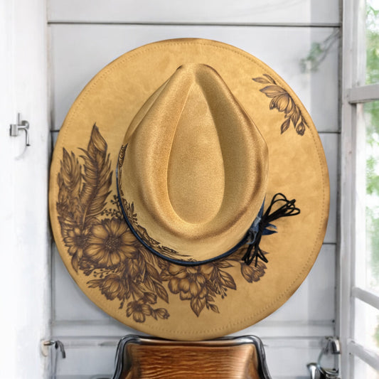 Camel brown Feather Play hat by Piper Hat Co. with burned floral artwork, overhead view