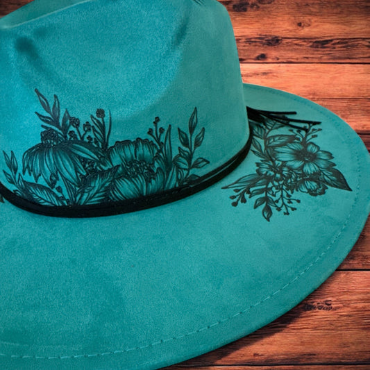 Close-up of the freehand floral artwork around the teal hat crown and brim