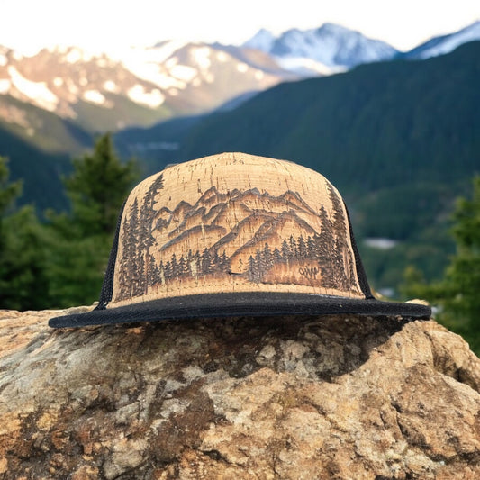 Piper Grand Tetons cork trucker with burned mountain artwork and black bill, outdoors