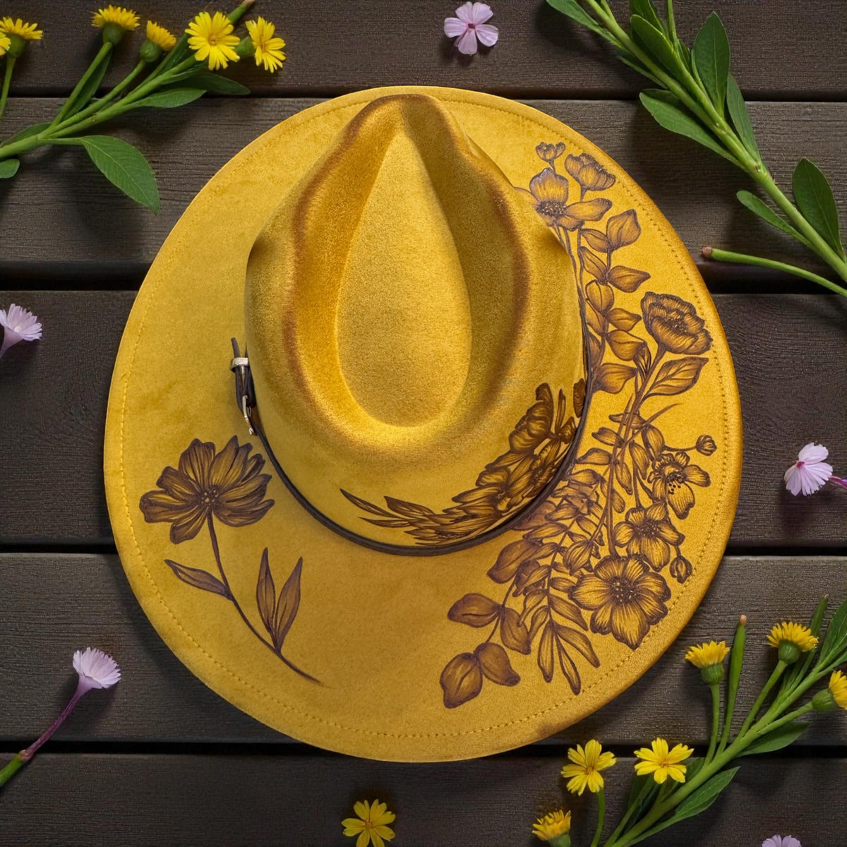 Mustard Honestly Wild fedora with burned wildflowers and leafy stems, overhead view