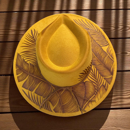 Overhead view of the mustard fedora showing the full botanical brim design