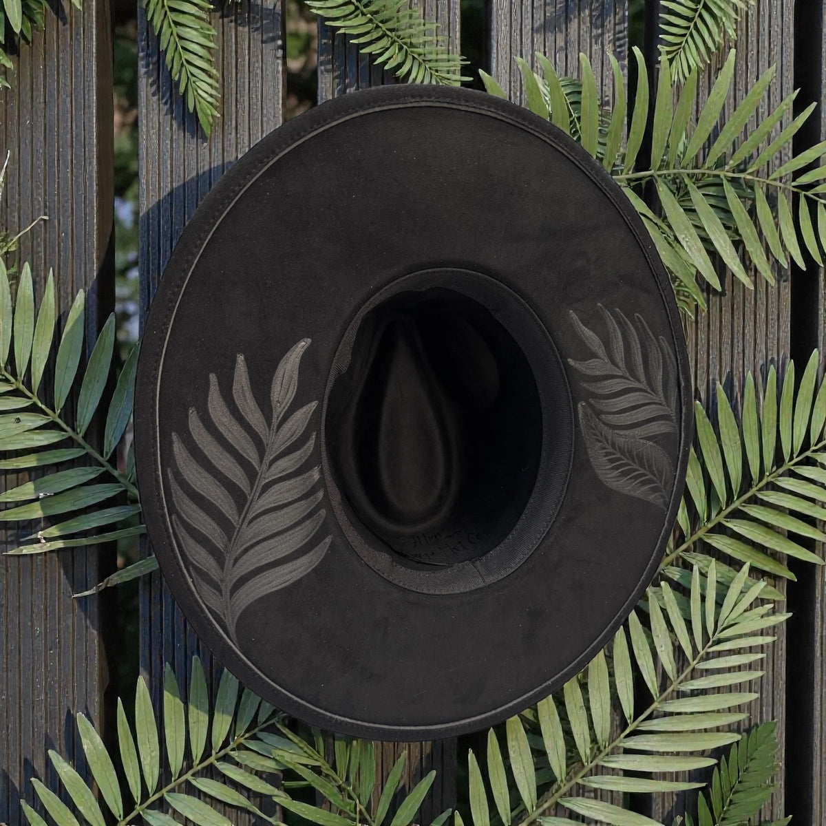 Underside of the black fedora showing the inner band and decorated brim