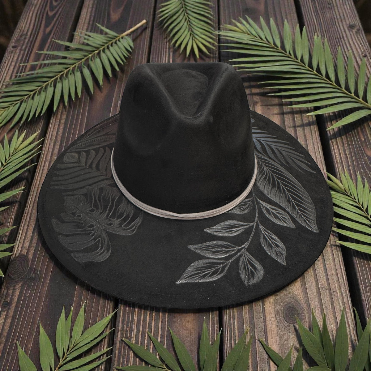 Black High Definition fedora with pale botanical artwork, front angled view
