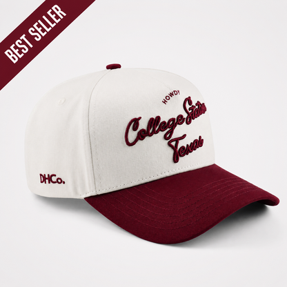Destination Hat Co. College Station beige and maroon script hat, angled front view
