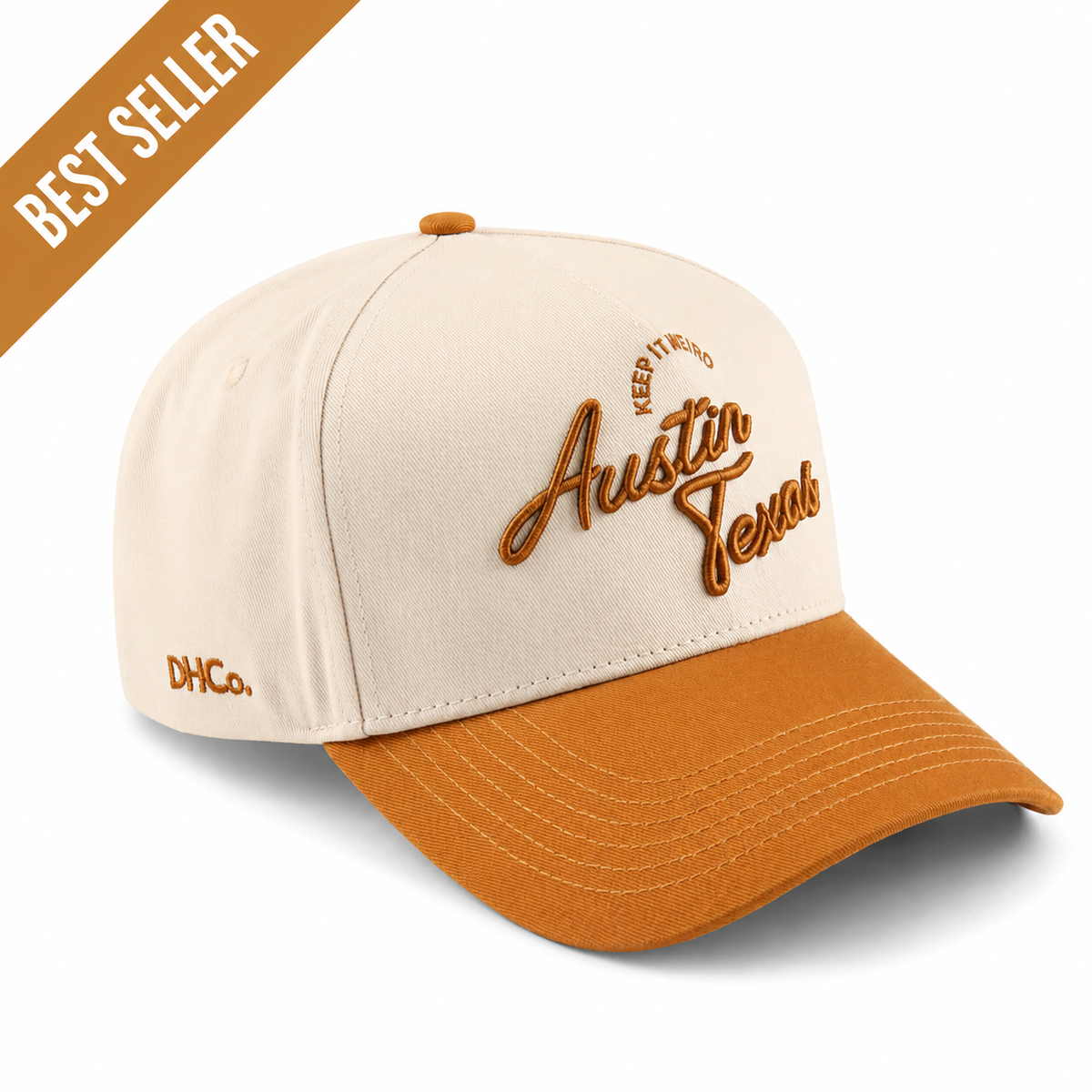 Destination Hat Co. Austin script cap with beige crown and orange bill, angled view