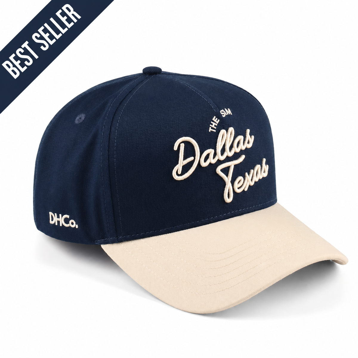 Destination Hat Co. Dallas script cap with navy crown and beige bill, angled view