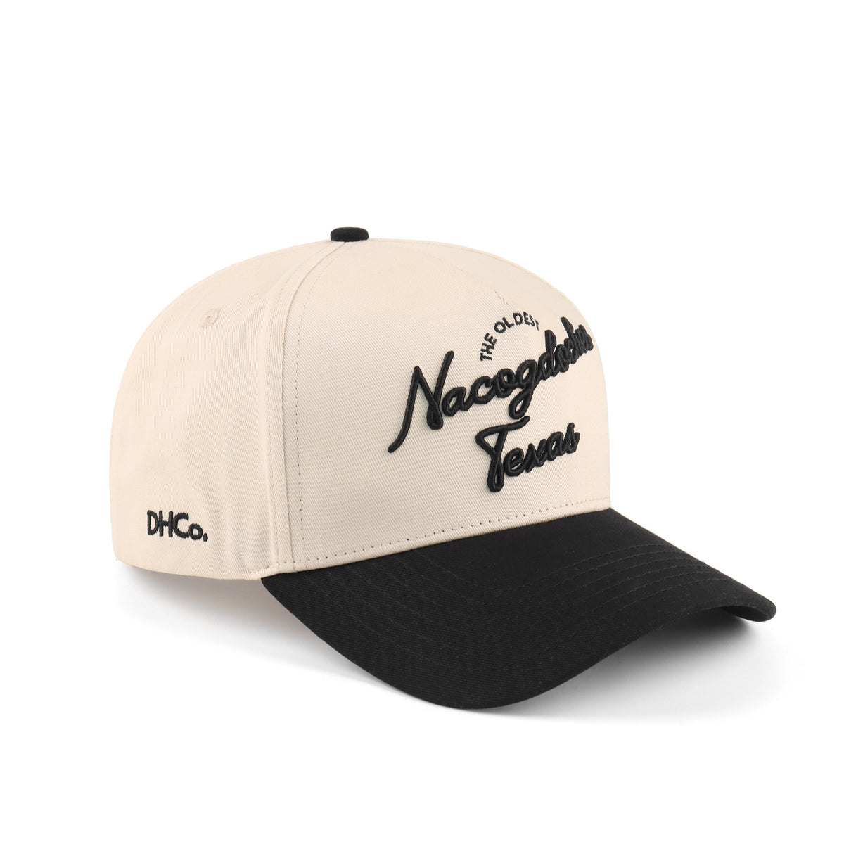Destination Hat Co. Nacogdoches script cap with beige crown and black bill, angled view