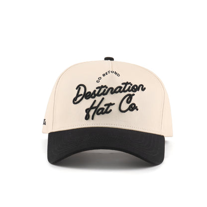 Front view of the Destination Hat Co. Destination script cap with black embroidery