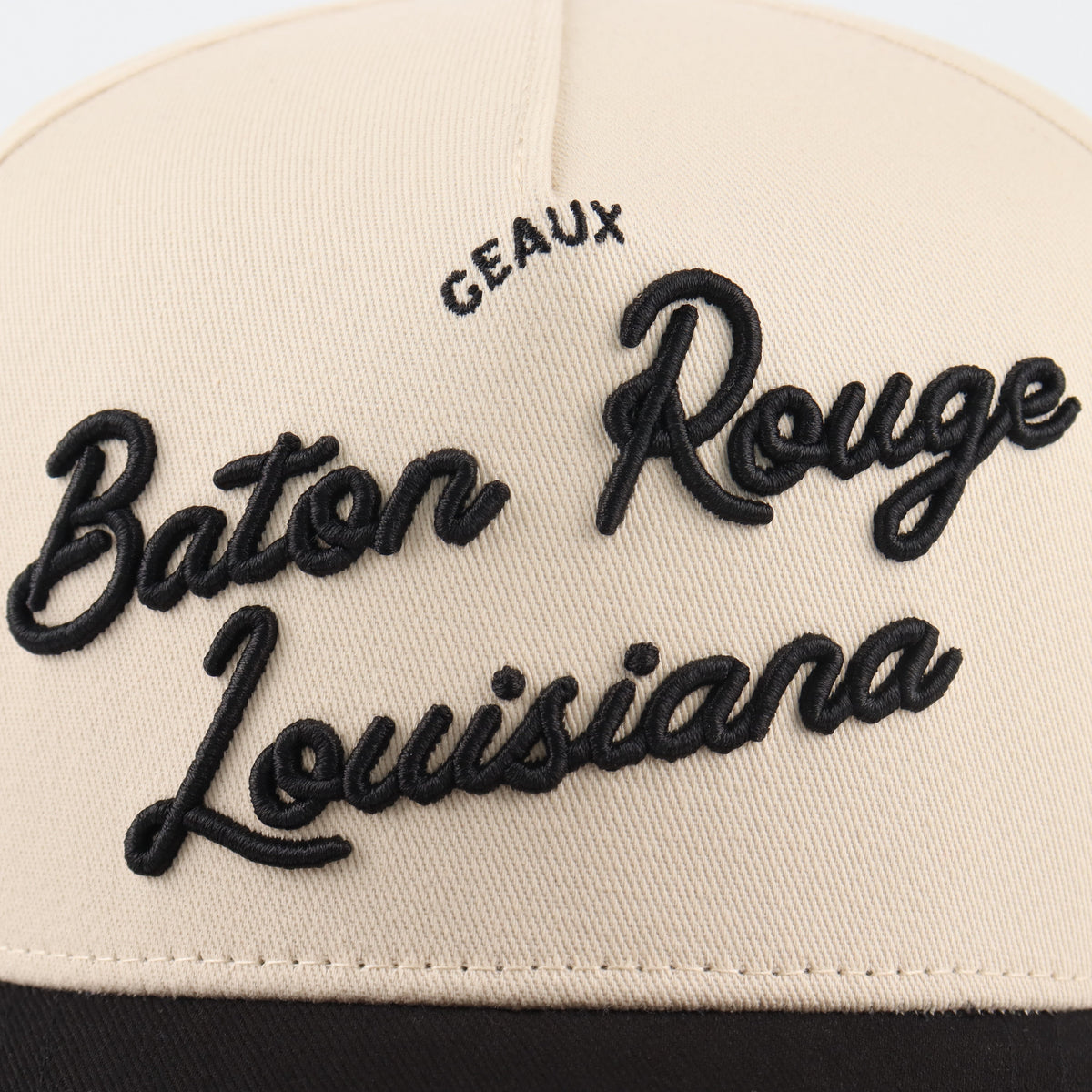 Close-up of the black Baton Rouge embroidery on the beige crown