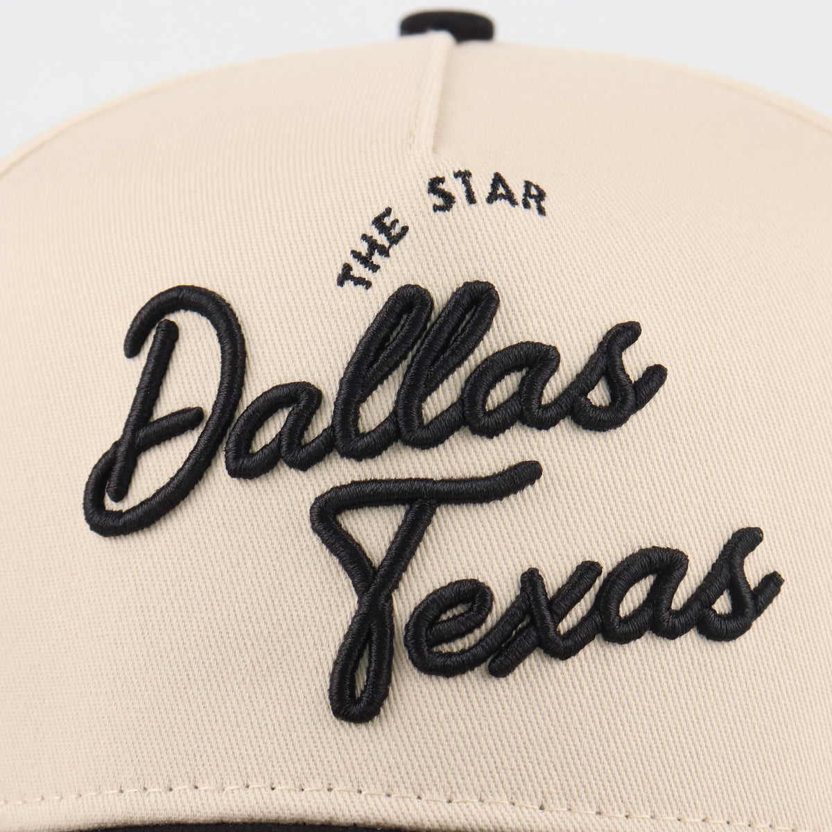 Close-up of the black Dallas embroidery on the beige crown