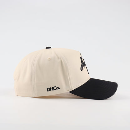Side profile of the Destination Hat Co. Austin script cap showing the curved bill and side logo