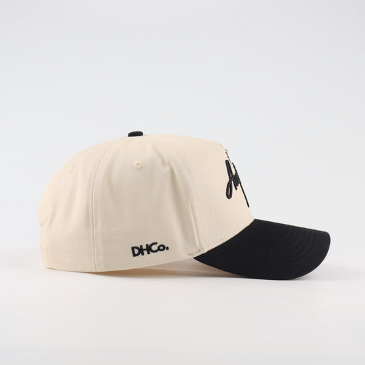 Side profile of the Destination Hat Co. Austin script cap showing the curved bill and side logo
