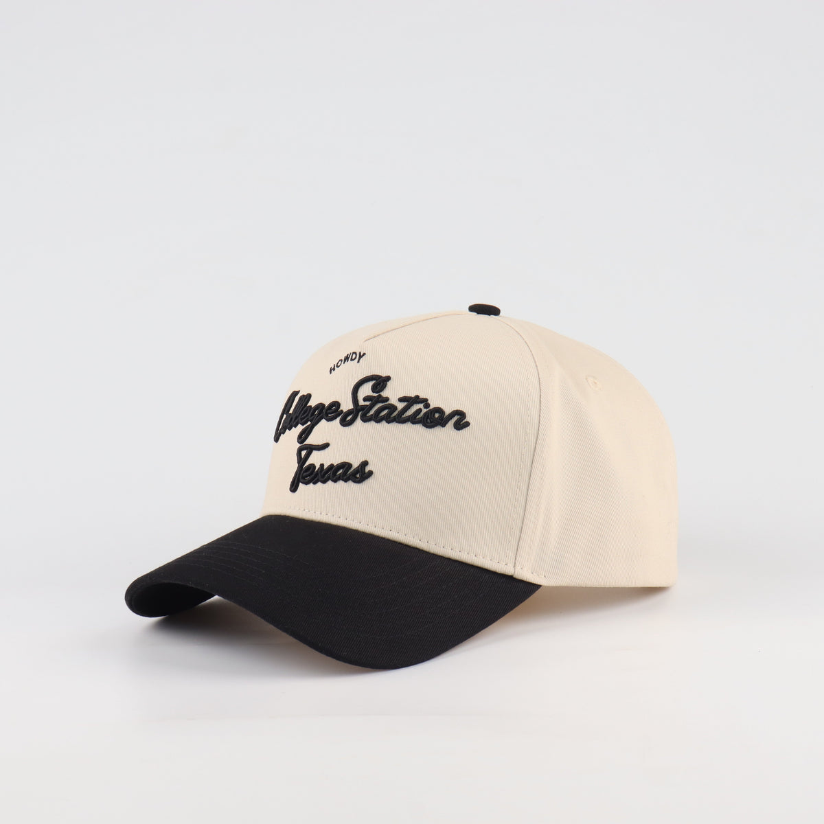 Opposite angled view of the Destination Hat Co. College Station script cap showing the black lettering