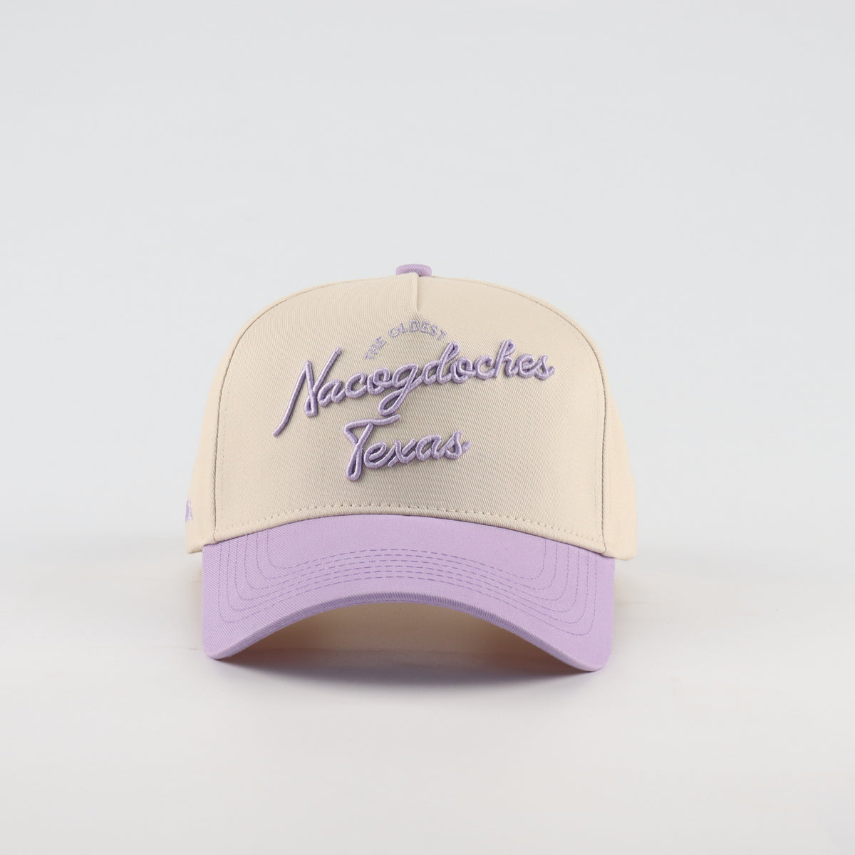 Front view of the Destination Hat Co. Nacogdoches script cap with purple embroidery