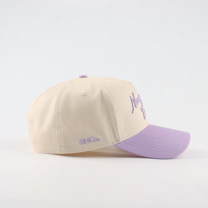 Side profile of the Destination Hat Co. Nacogdoches script cap showing the curved bill and side logo