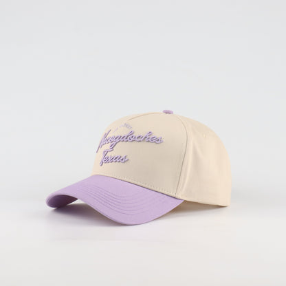 Opposite angled view of the Destination Hat Co. Nacogdoches script cap showing the purple lettering