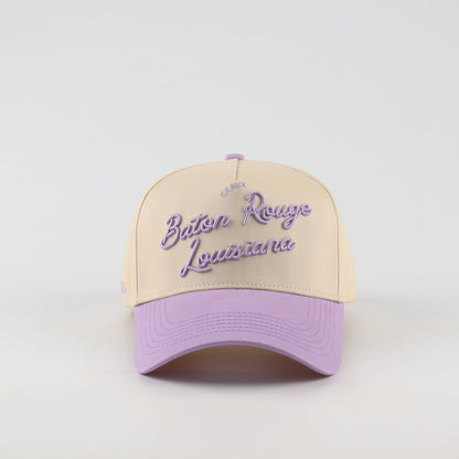 Front view of the Destination Hat Co. Baton Rouge script cap with purple embroidery