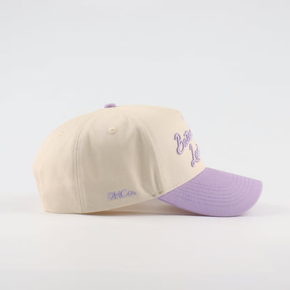 Side profile of the Destination Hat Co. Baton Rouge script cap showing the curved bill and side logo