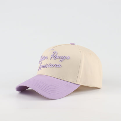 Opposite angled view of the Destination Hat Co. Baton Rouge script cap showing the purple lettering