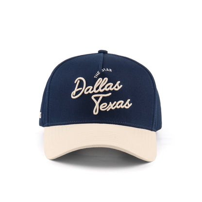 Front view of the Destination Hat Co. Dallas script cap with beige embroidery