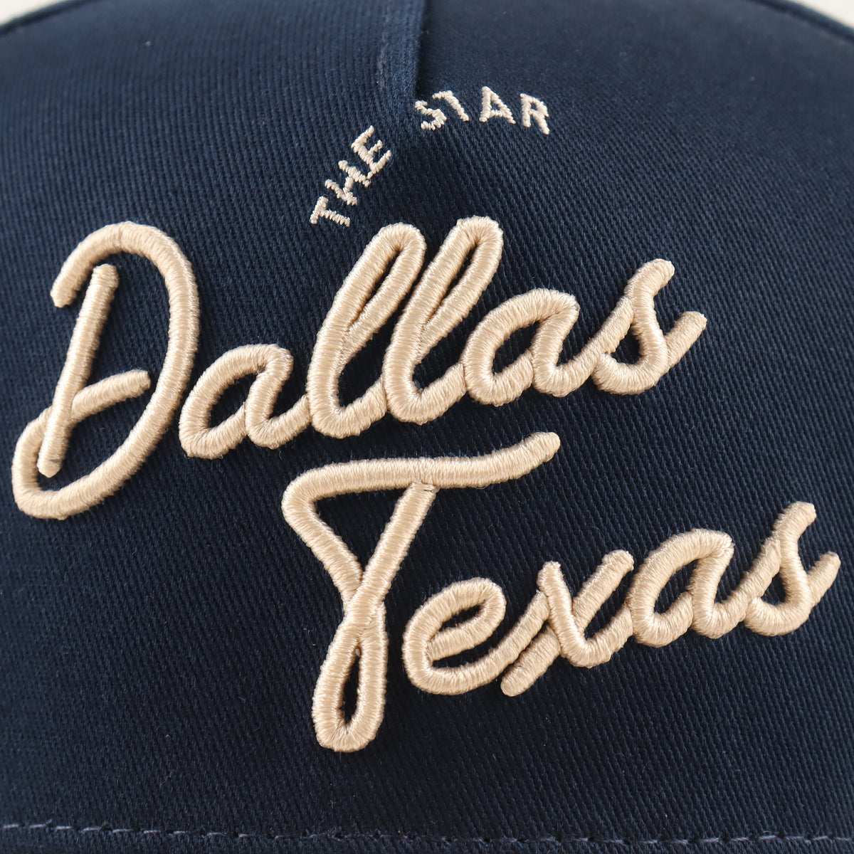 Close-up of the beige Dallas embroidery on the navy crown