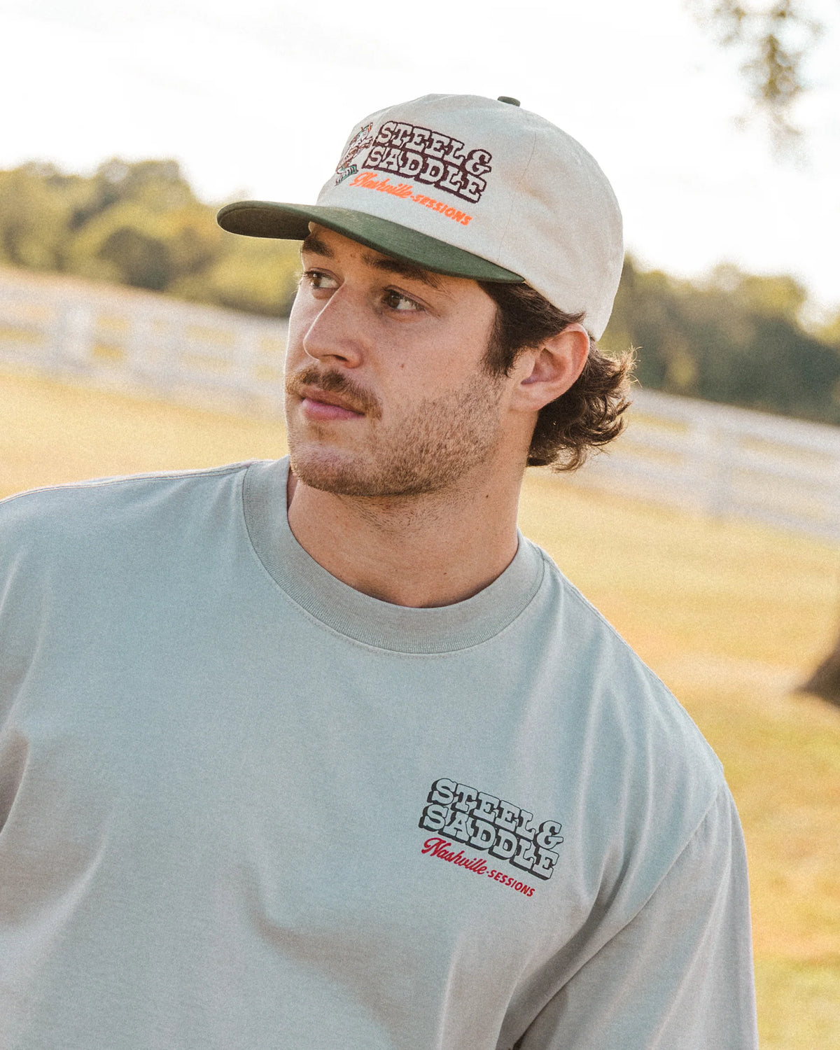 Model wearing the Nashville Sessions Hat beside a tree