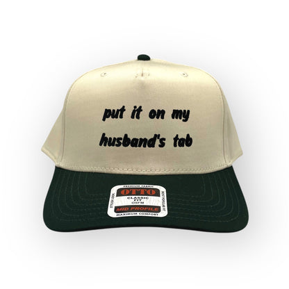 Front view of Put It on My Husband's Tab cap by Horizon Hat Co. in Natural/Green showing put it on my husband's tab front embroidery