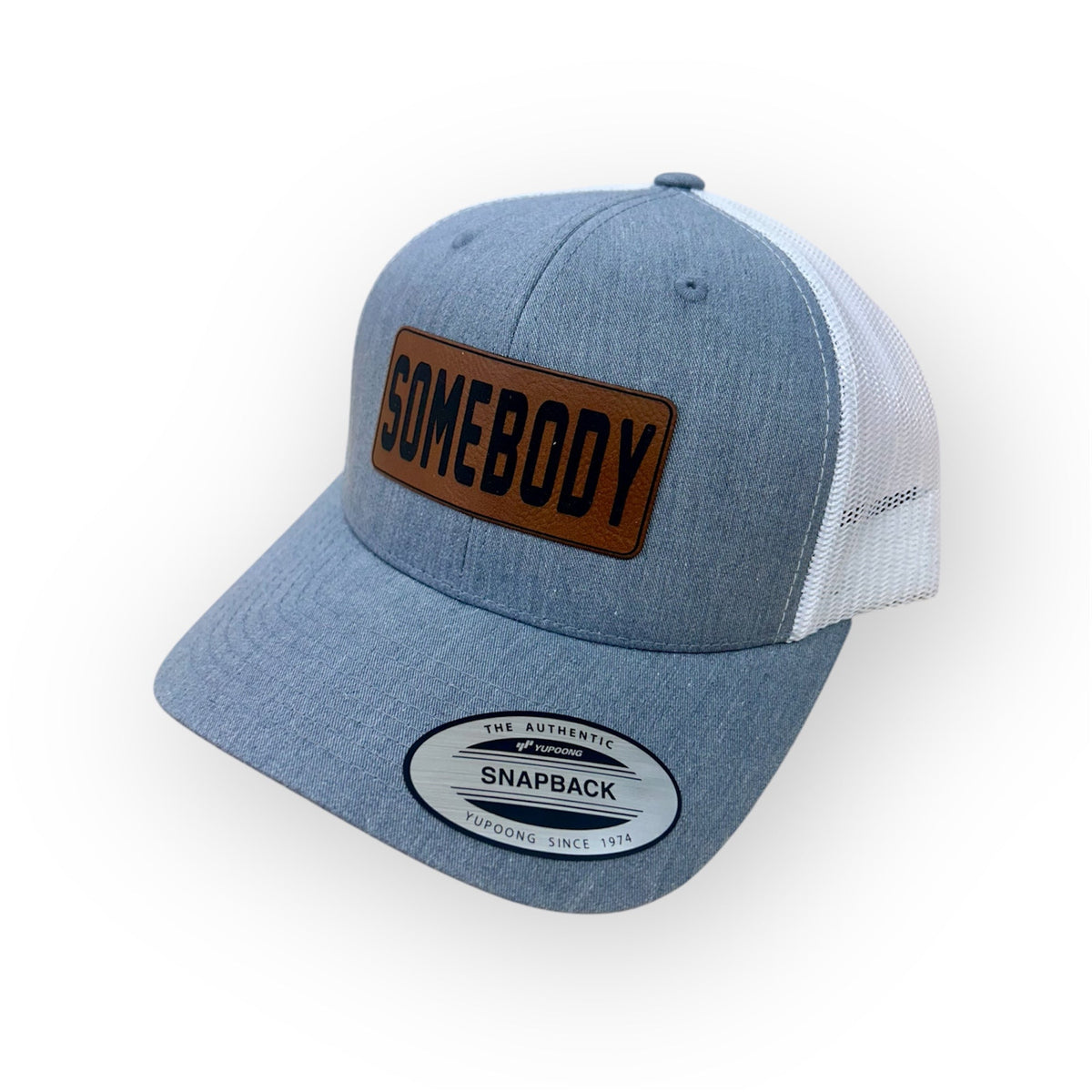Angled view of the SOMEBODY patch hat in the Horizon Hat Co. two-hat bundle