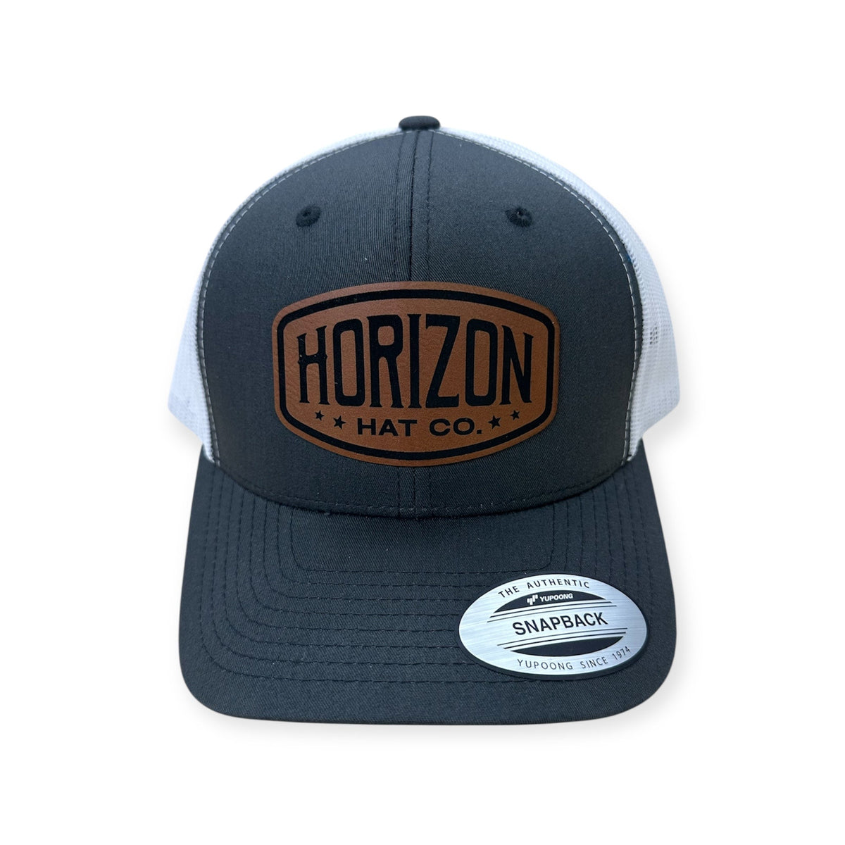 Charcoal and white Horizon cap with a rawhide-colored logo patch