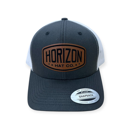 Charcoal and white Horizon cap with a rawhide-colored logo patch