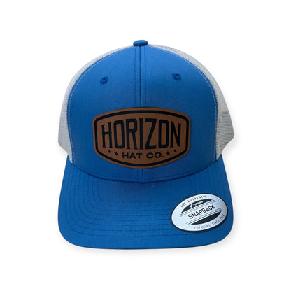 Steel blue and silver Horizon cap with a rawhide-colored patch