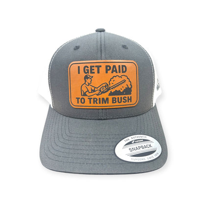 Front view of I Get Paid to Trim Bush patch hat by Horizon Hat Co. in gray/white showing hedge-trimming figure and landscaping-humor patch