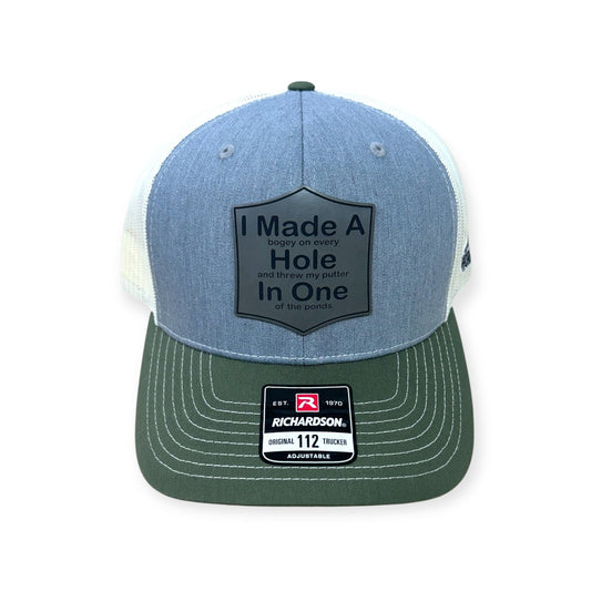 Front view of Hole In One patch hat by Horizon Hat Co. in gray/birch/olive showing golf-humor patch about a hole in one, bogeys, and a putter in a pond