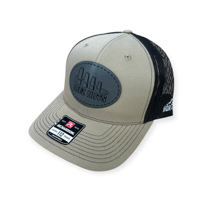 Angled view of Deez Nuts patch hat by Horizon Hat Co. in khaki/brown showing the curved bill and side panels