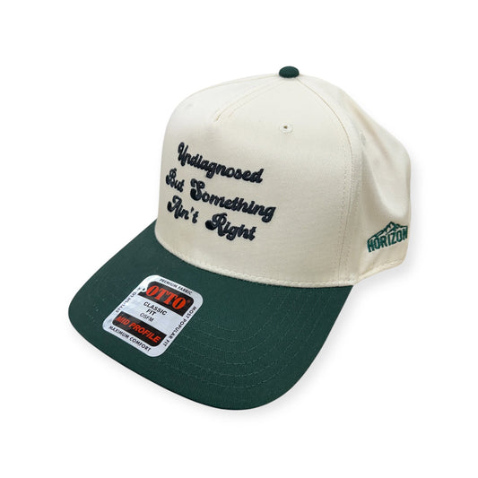 Angled view of the natural and green embroidered Otto cap