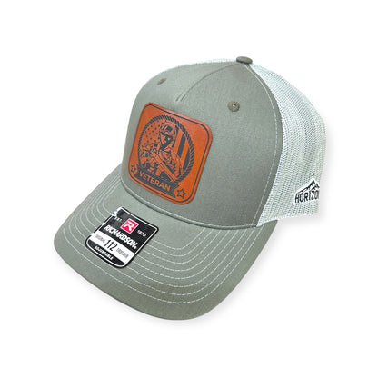 Angled view of Veteran #2 patch hat by Horizon Hat Co. in beetle/quarry showing the curved bill and side panels