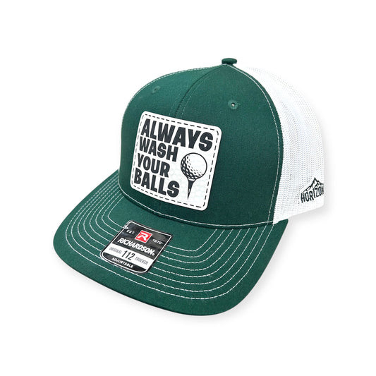 Angled view of Always Wash Your Balls patch hat by Horizon Hat Co. in dark green/white showing the curved bill and side panels