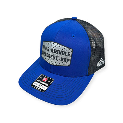 Angled view of Same Asshole, Different Day patch hat by Horizon Hat Co. in royal blue/black showing the curved bill and side panels