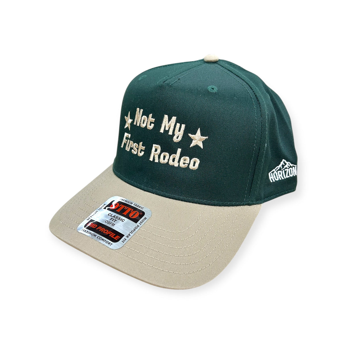 Angled view of Not My First Rodeo embroidered cap by Horizon Hat Co. in green/natural showing the bill and side panels