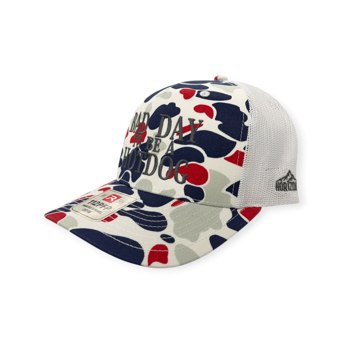 Angled view of Bad Day To Be A Hotdog patch hat by Horizon Hat Co. in americana duck camo showing the bill and side panels