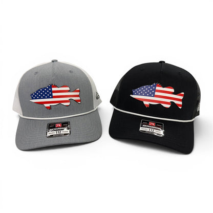 Gray and black Freedom Bass caps arranged together with flag-filled fish artwork