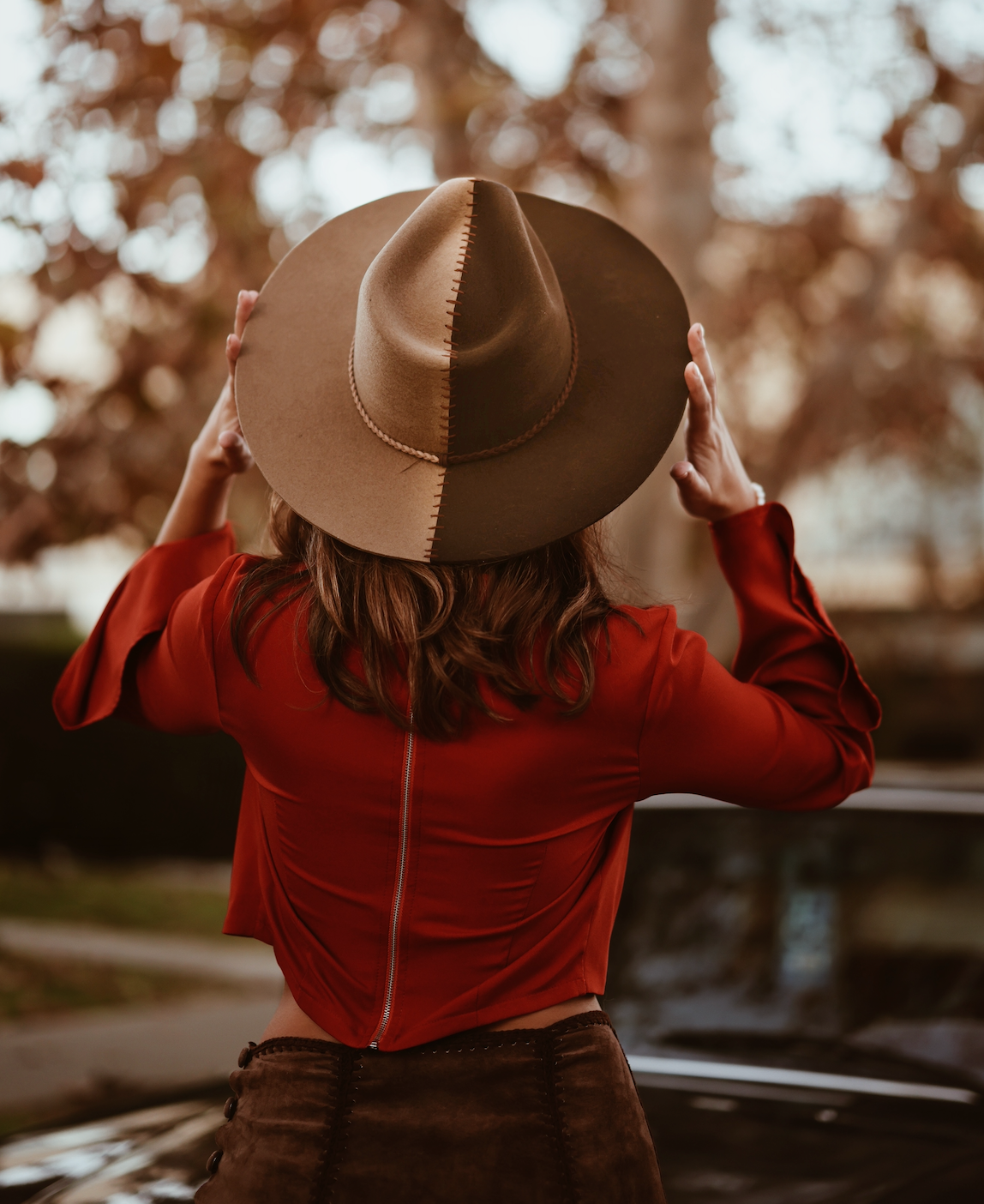 ASN Hats Cruel Intentions - Brown & Tan brown and tan fedora hat, rear view on a model in a red blouse