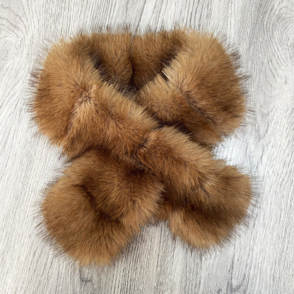Golden brown segmented faux fur scarf shown in a crossed loop