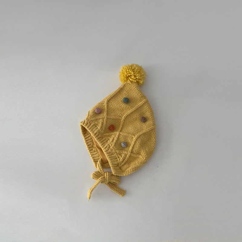 Yellow pom pom bonnet with cable-knit panels